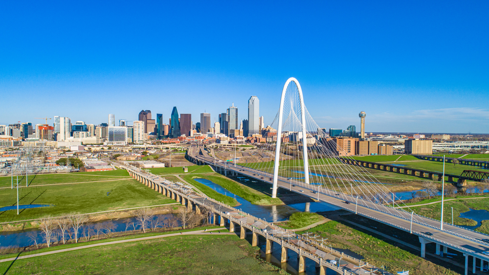 the view of Dallas Texas from above. you can see the big bridge letting cars into town and the downtown area in the back 