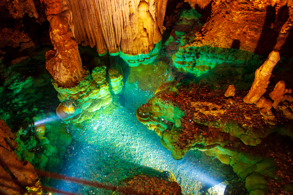 inside the wishing well of the luray caverns in virginia. the reflection of the light makes the wishing well look green and the beautiful caverns a dark orange.