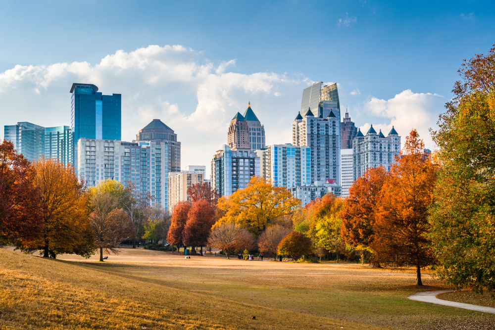 Georgia during the fall with trees filled with orange and the Atlanta skyline in the background during the day