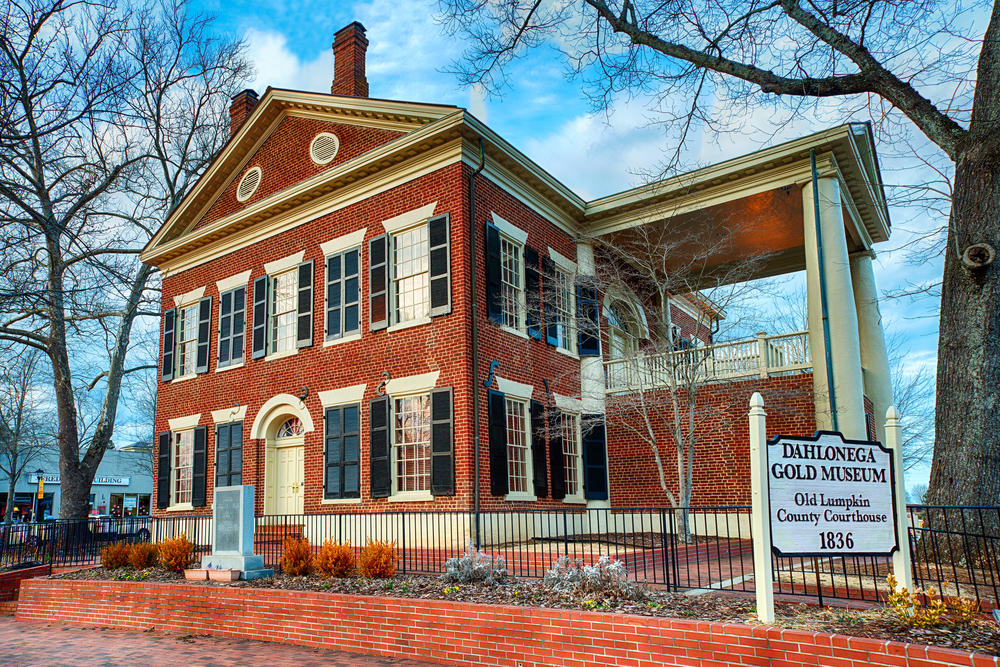 The Dahlonega Gold Museum located in Dahlonega, with trees bare of leaves with a blue sky and overcast, what you will find at one of the best small towns in Georgia 