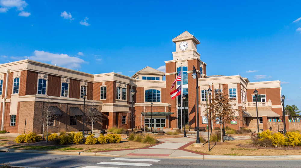Lilburn City Hall during a clear sunny day with an American Flag flight on a pole at the front of the building