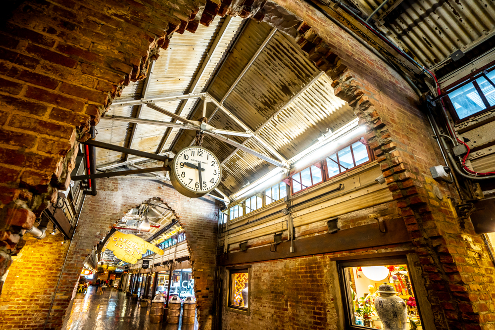 the inside of the Chelsea market in NYC. with old stone and clocks, this is one of the best places to visit during your Weekend in NYC