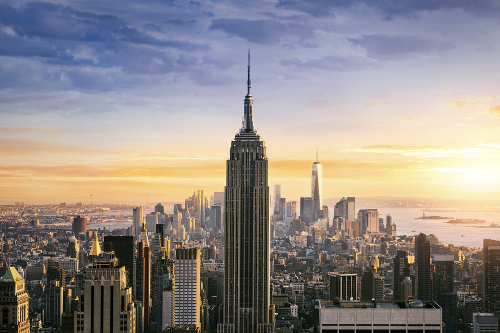 the Empire State building at sunset. this Empire State Building stands taller than all the other buildings around and has a big point on the end