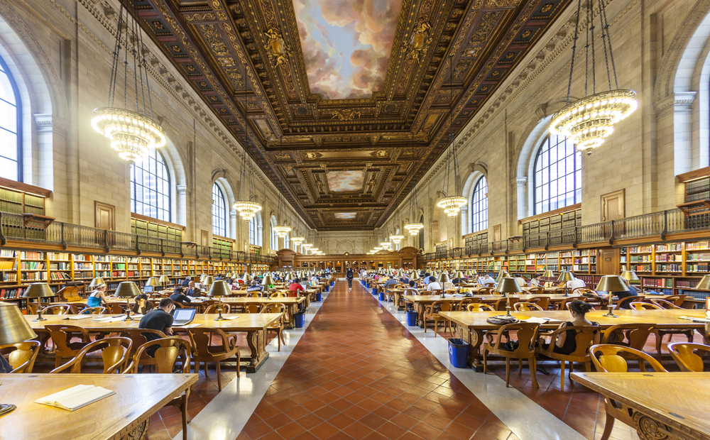 the inside of the New York Public Library with a beautiful painting on the ceiling and hanging lights in the middle and hundreds of books on the shelfs 