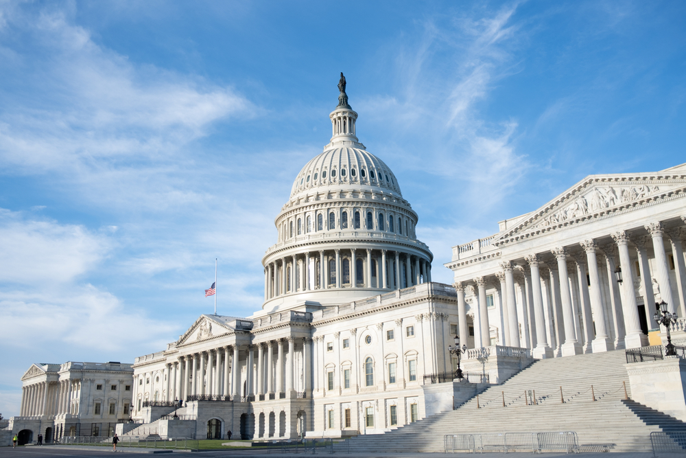 the capital building in DC on a sunny day. there are large stair cases, and beautiful architecture. 