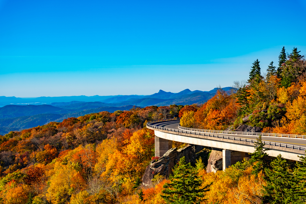 the blue ridge parkway curves the mountain the the photo in autumn, mountains in the background on a clear day