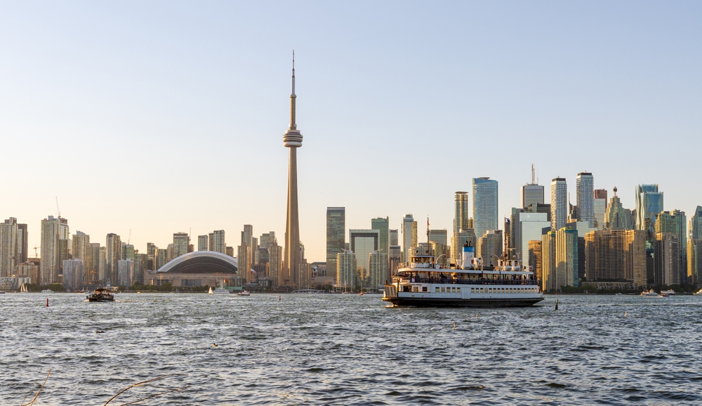 a great view over the water with a large boat, cruising through the lake and showing off Toronto's amazing skyline!