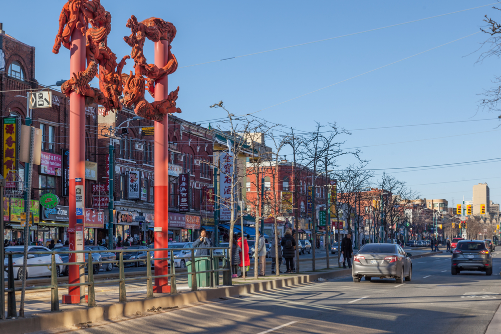 a great image of Chinatown in winter, with bright red towers indicating the neighbourhood and lovely bright buildings, the perfect destination for a weekend in Toronto!