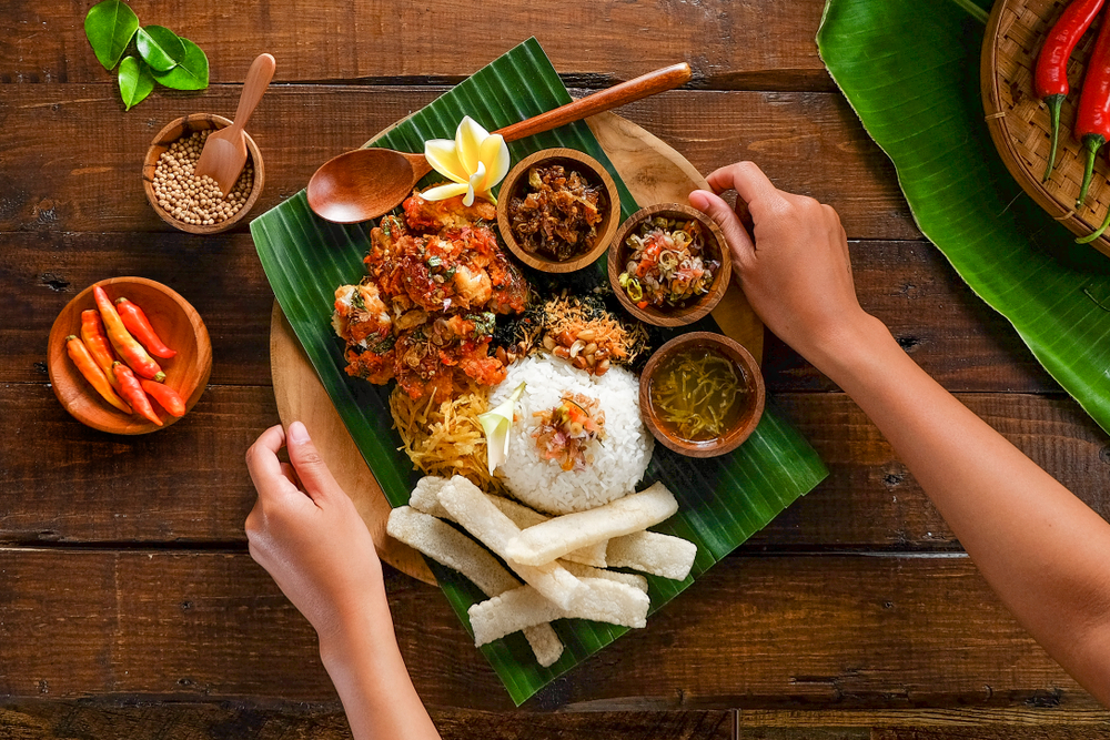 beautiful wooden plate with a palm leaf, rice, beautiful veggies and meats ready to be devoured!