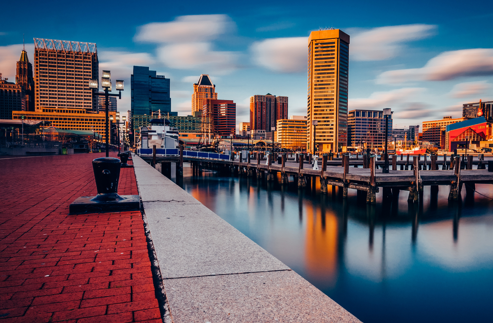 the beautiful view of the Baltimore Inner Harbor at sunset with the beautiful buildings reflecting into the water. 