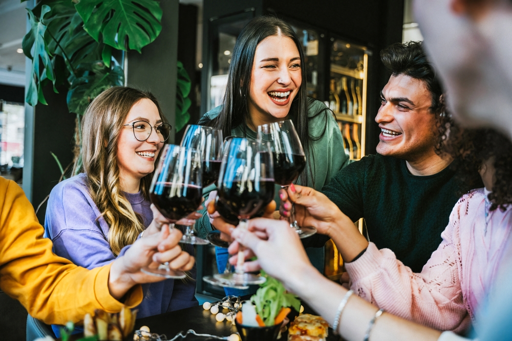 a group of friends drinking wine and laughing at a French wine bar