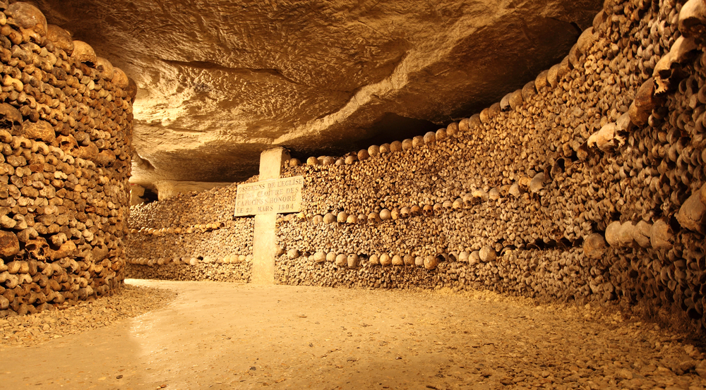 the catacombs underground in Paris with arrranged skulls