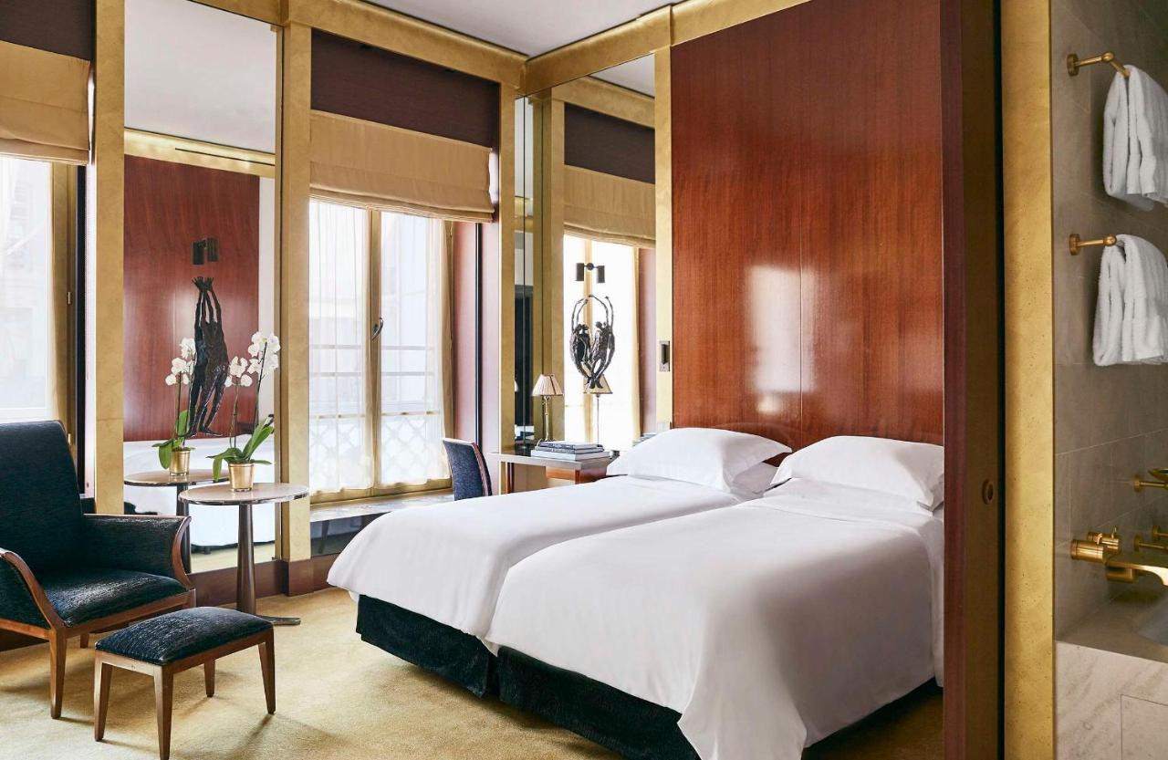 the bedroom at the Park Hyatt Paris with dark finishings and gold at this 5 star hotel in Paris