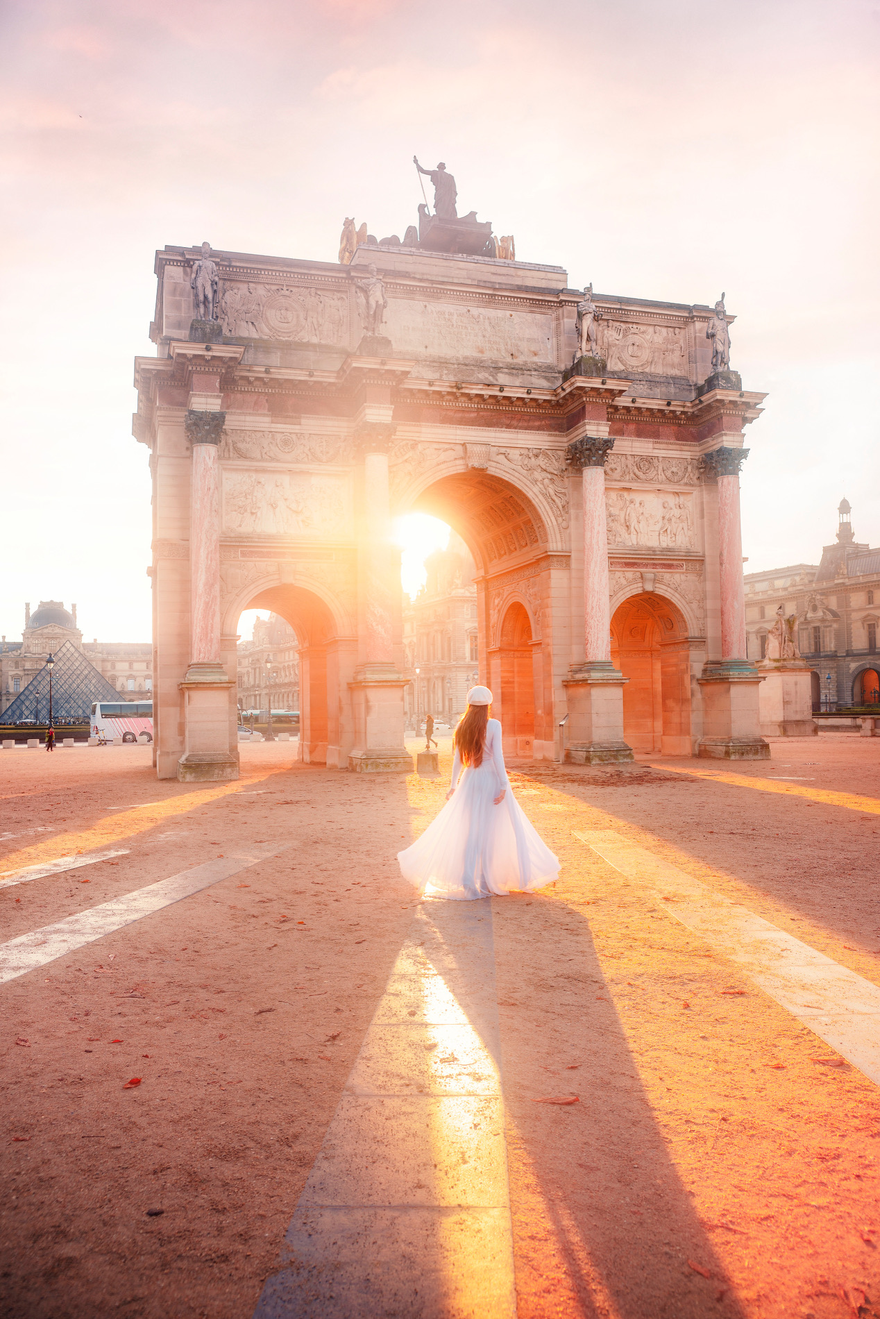 a girl in white dress standing in front of one of the french monuments
