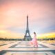 a girl in a pink skirt dancing in front of the Eiffel Tower at Sunrise