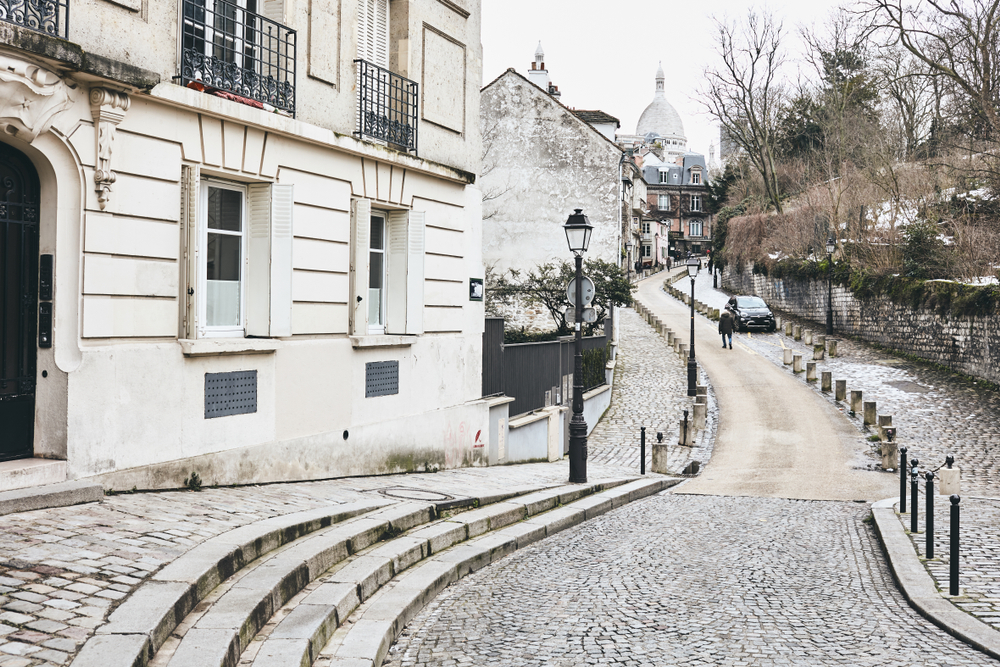 Famous hilly street in Montmartre Paris leading up to the Sacre Coeur dusted with snow.