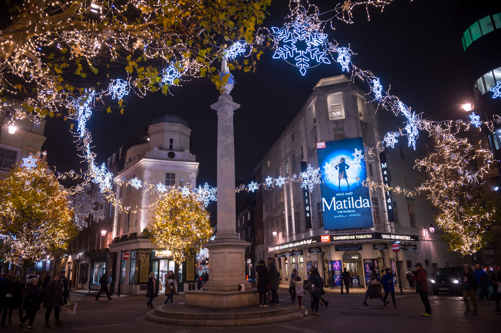 Christmas lights over a square next to a theater with a sign for "Matilda the Musical."