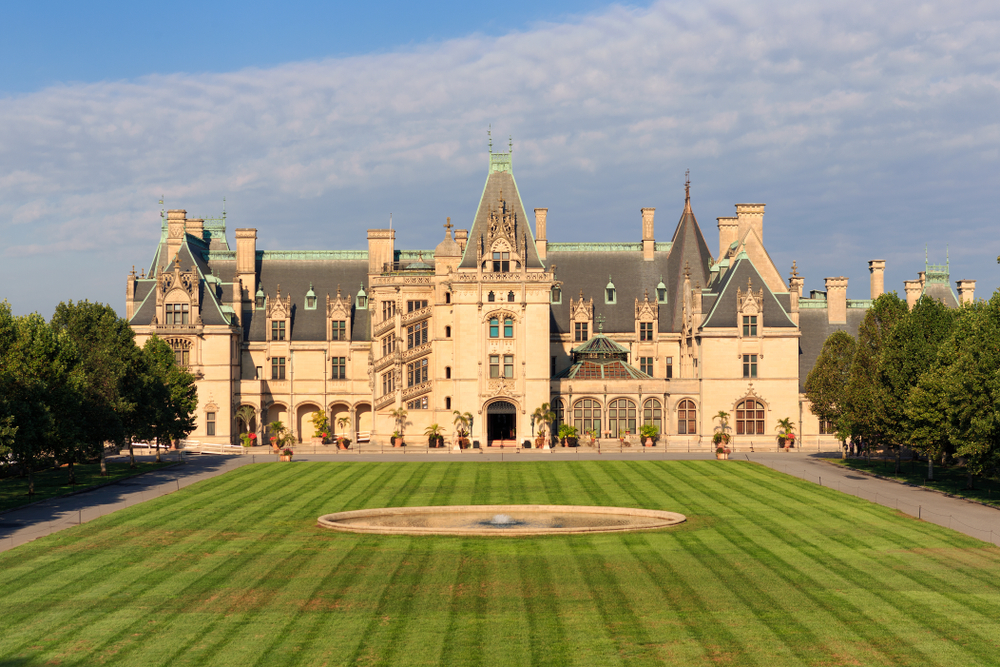 the front of the Biltmore Estate during the day with a green lawn with alternating dark green and light green rows, where you might spend one of the best weekend getaways in North Carolina 