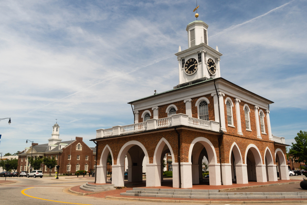 historic buildings located in downtown Fayetteville, with brick and white wood and a clock at the top of the building during the day with overcast skies 