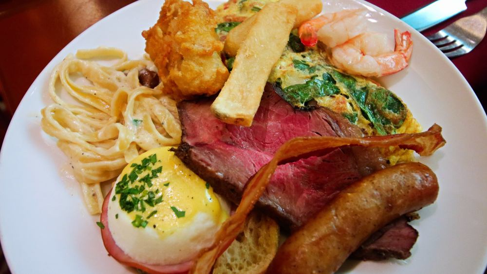 A white plate full of a variety of foods that you can find at a buffet