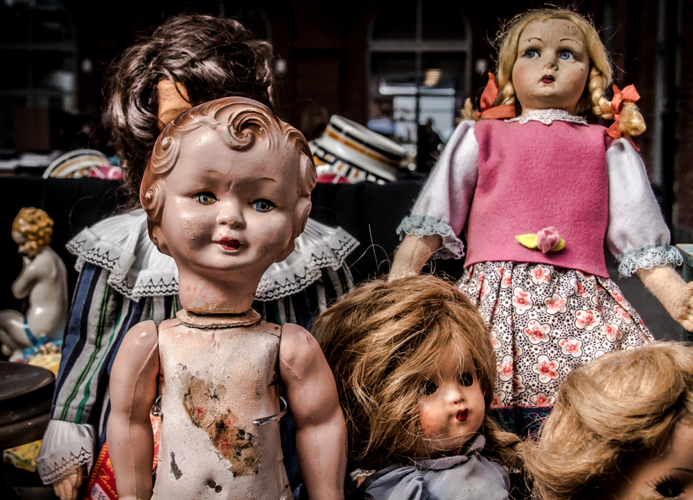 A group of creepy dolls in a musuem