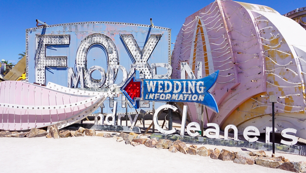 A group of old neon signs on display outside at a museum during the day during a weekend in Las Vegas