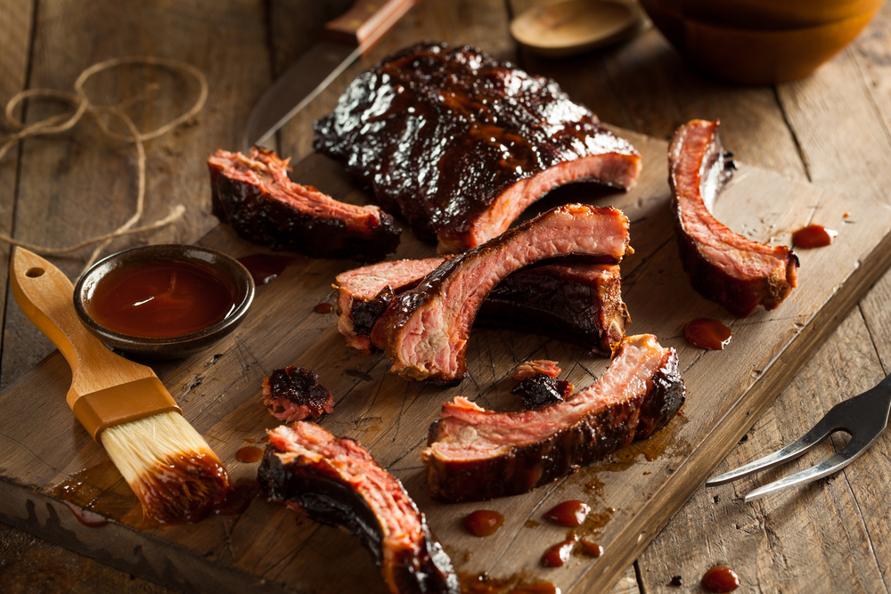 A wooden plate covered in bbq ribs