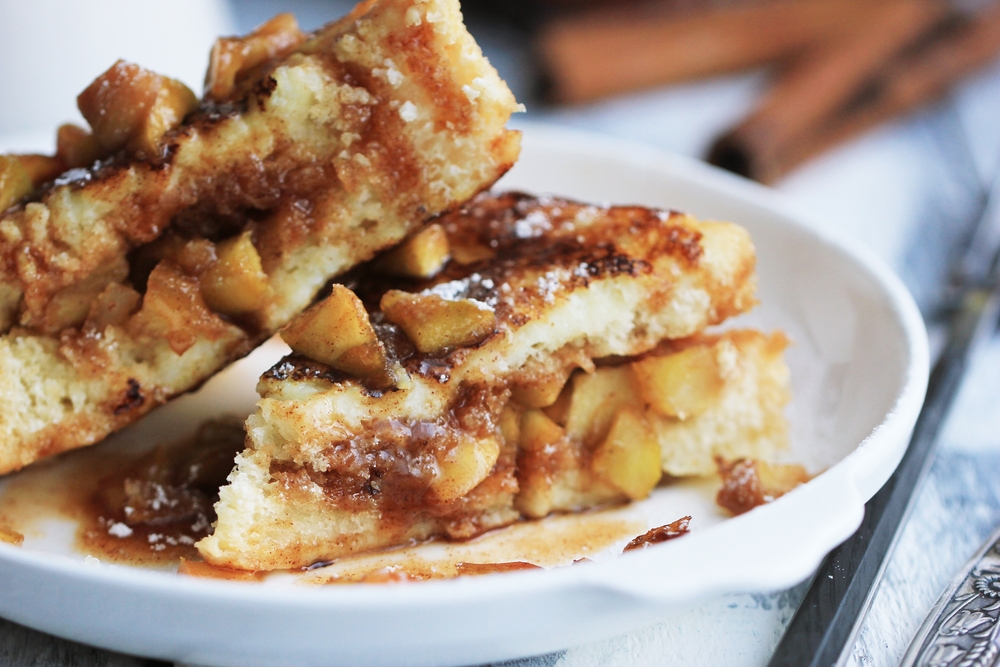 A white plate loaded with cinnamon apple stuffed french toast