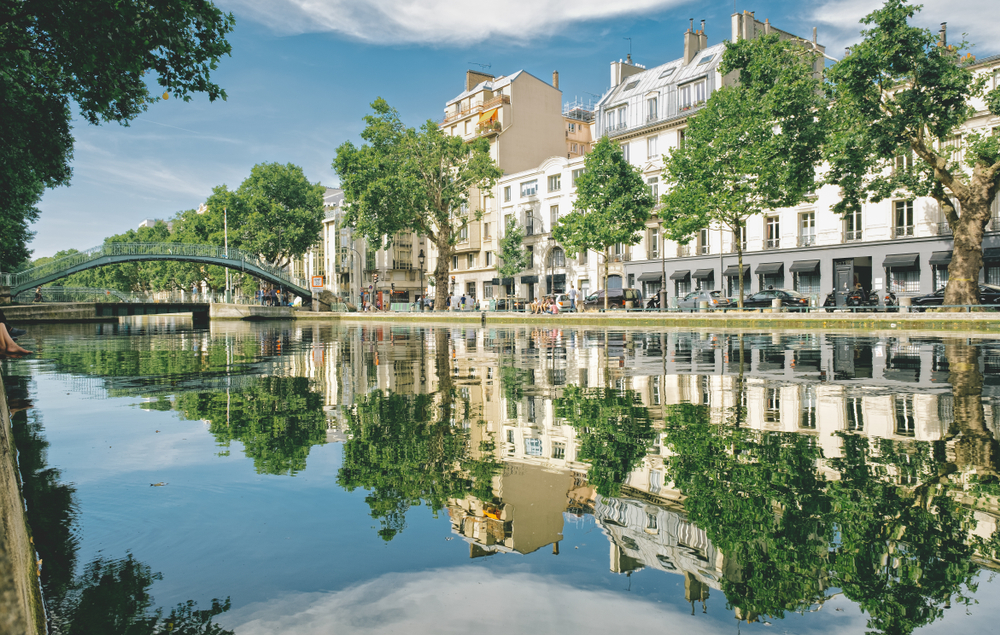 a view of the charming residental area of Canal St. MARTIN  with river locks and trees surrounded by buildings