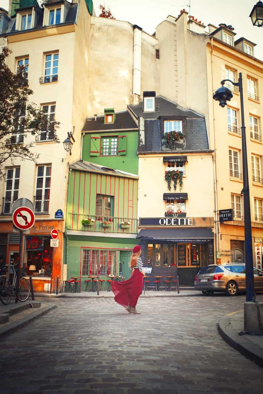 a girl in a red skirt is standing int he middle of the street standing in the latin Quarter