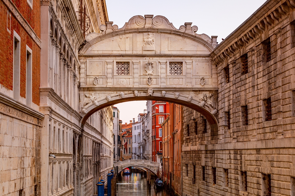 The stone Bridge of Sighs over a small canal in Venice.
