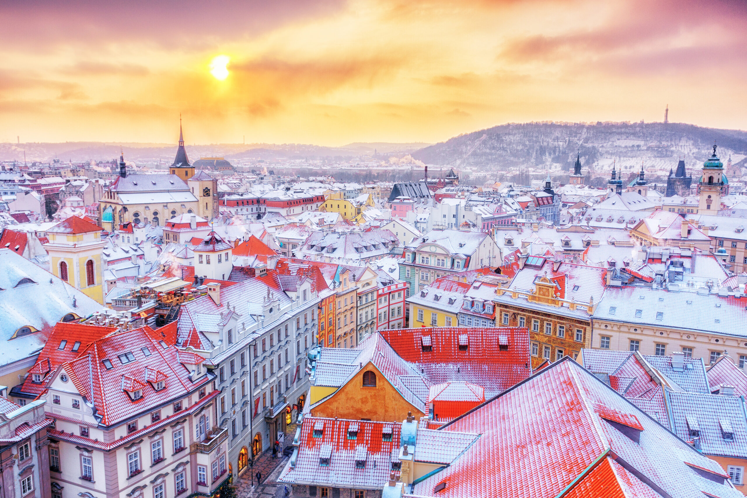 View of a beautiful sunset over the colorful downtown streets dusted with snow in Prague 