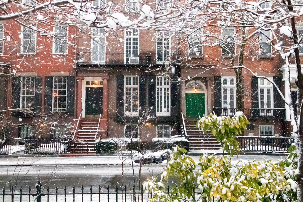 Brick townhouses in New York City seen through falling snow.