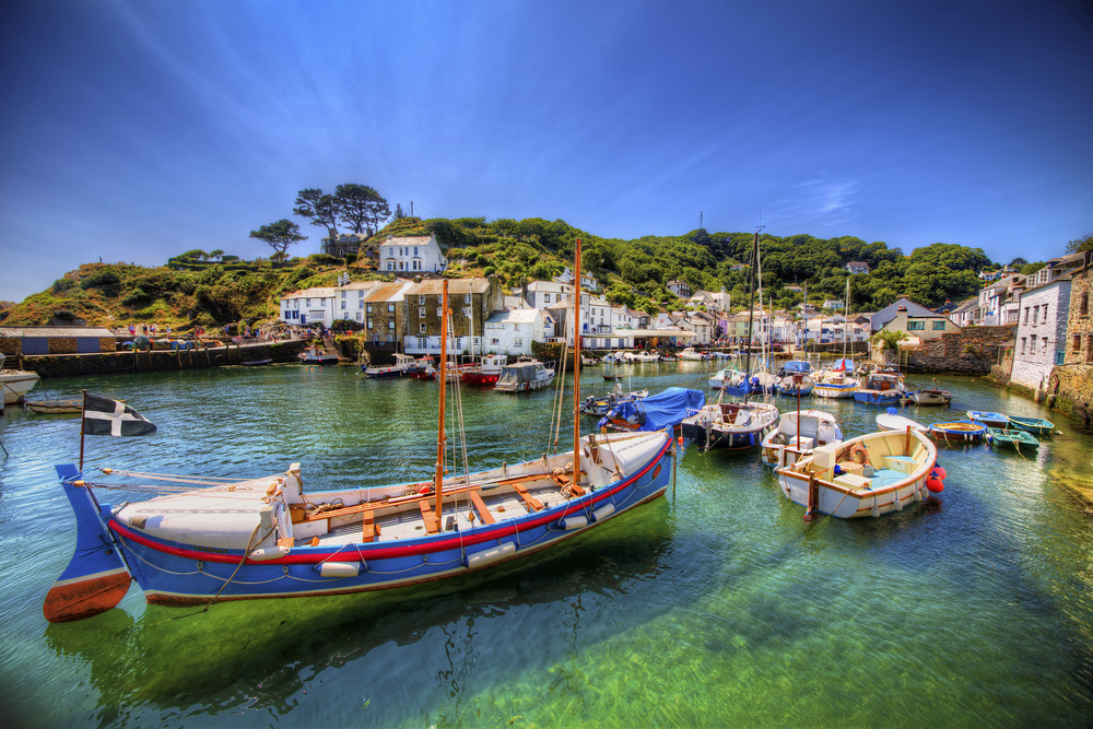 Harbour showing boats in the foreground and houses in the background .  One of the English villages to visit. 