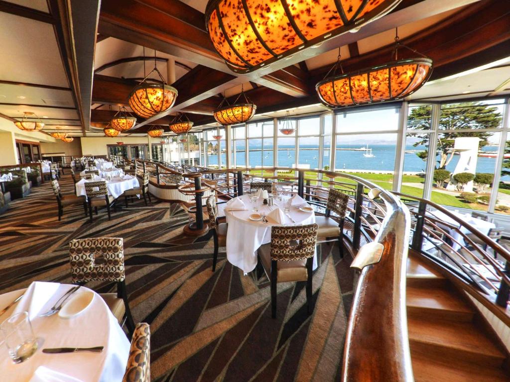 Hotel restaurant showing set tables the restuarant overlooks the ocean and landscaped grounds. 