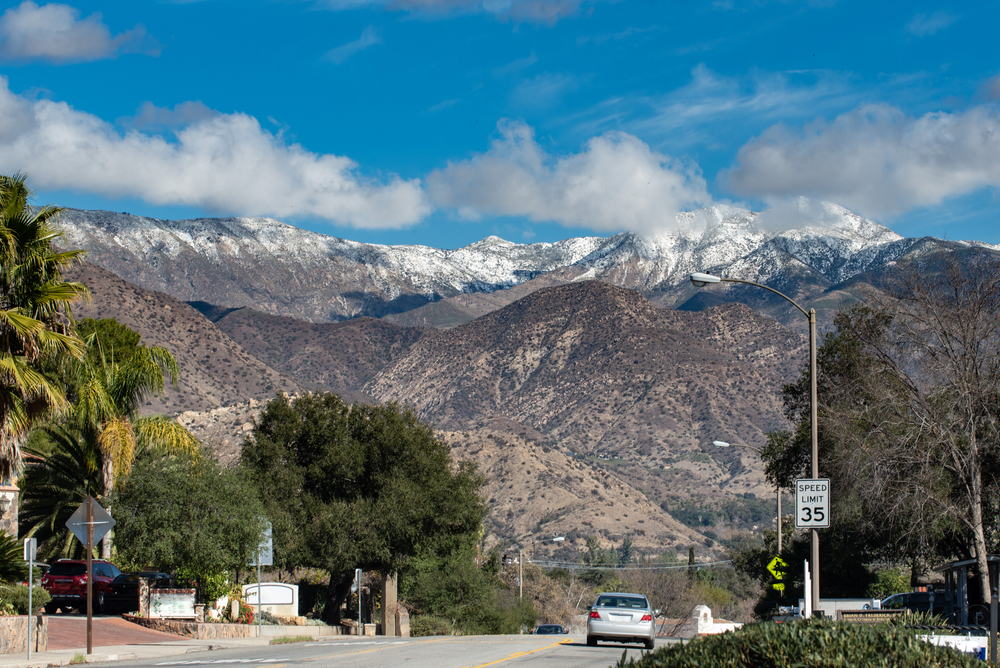 Chiefs Peak Mountain over Ojai, California is covered in snow and low clouds while overlooking highway