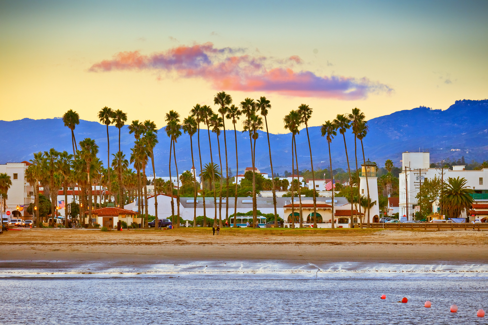 View on Santa Barbara from the pier showing the beach, palm trees and buildings. 