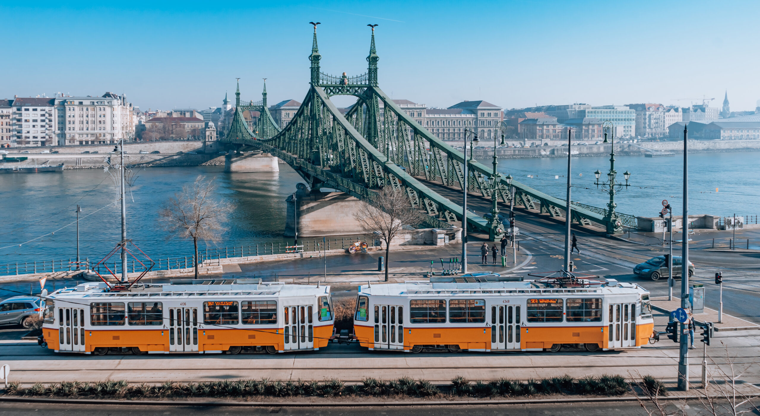 View of the cheery yellow Budapest tram running besides the Danube river