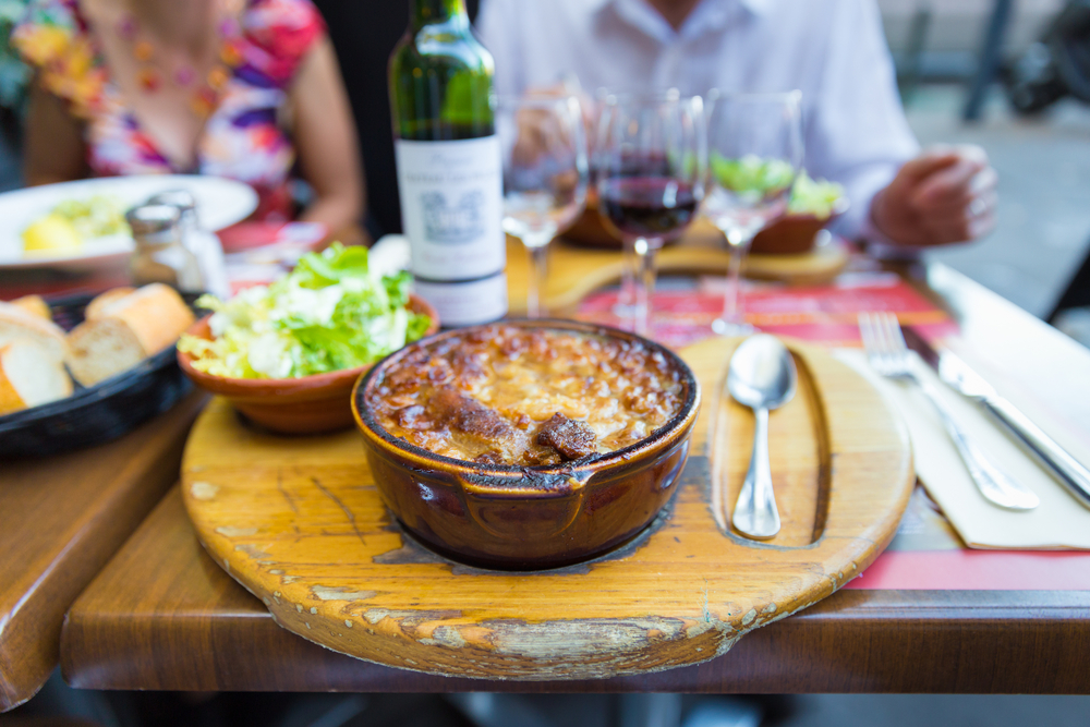 a French meal at lunch with soup, salad, bread and wine with a group