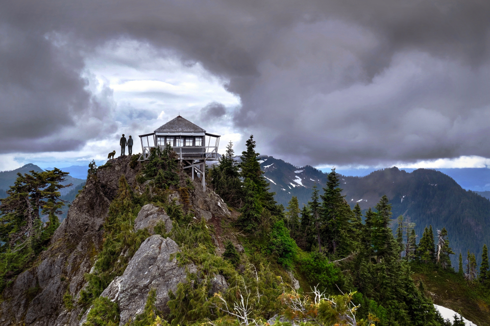 Old fire lookout set on a rugged mountain ridge above the 