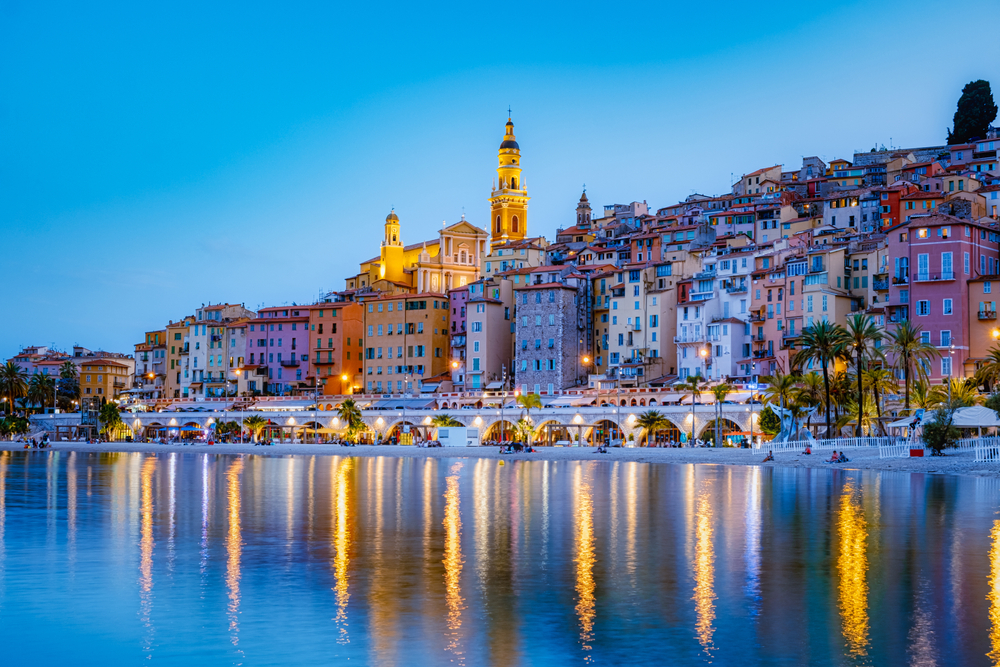 Dusk over Menton with lights reflecting in the water along the beach during one week in Europe.