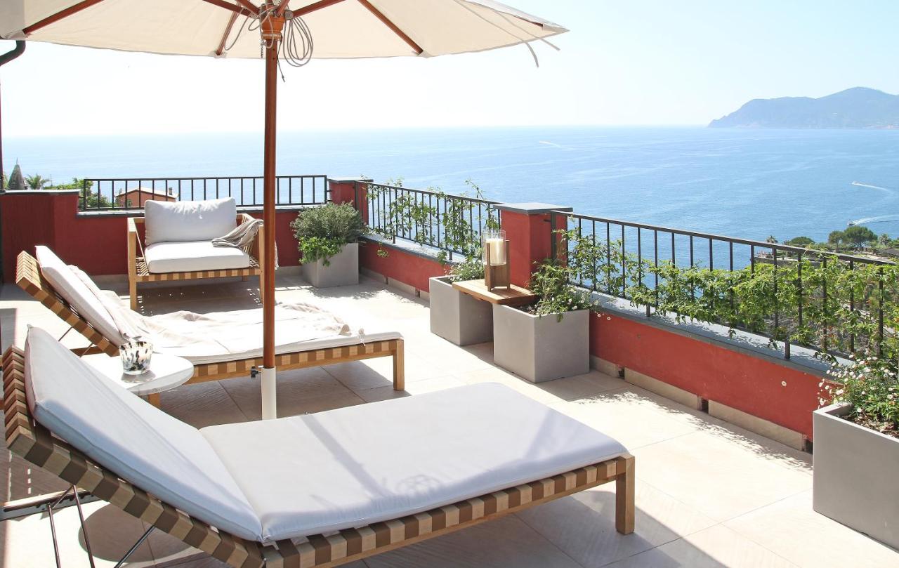 Cushioned lounge chairs on a rooftop overlooking the ocean at Il Sogno di Manarola by The First.