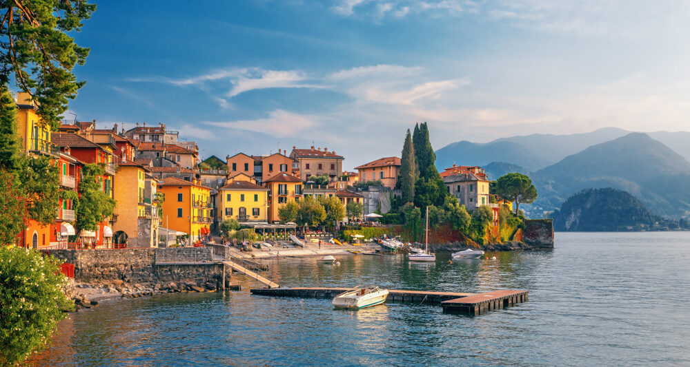 beautiful homes and houses in lake como in nothern italy with trees and a lake in the foreground