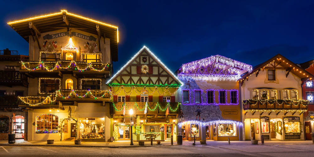 Bavarian-styled buildings covered in colorful Christmas lights at night in Leavenworth.