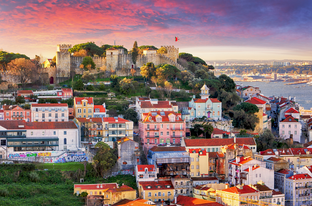 Sunset over the colorful building of Lisbon featuring Saint George's Castle.
