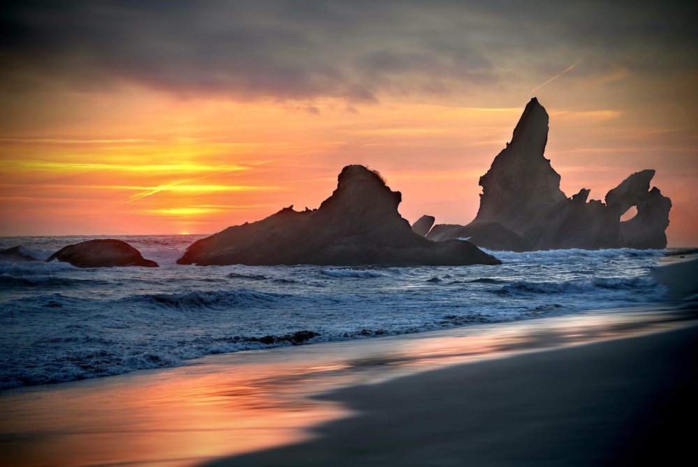 Vivid sunset over Shi Shi Beach with rugged sea stacks in the waves.