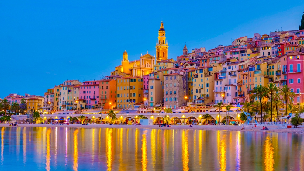 the beautiful view of the French Rivera in February. this is right at dusk when the orange street lights have turned on and the city if glowing. this is one of the best places to visit in Europe in February 