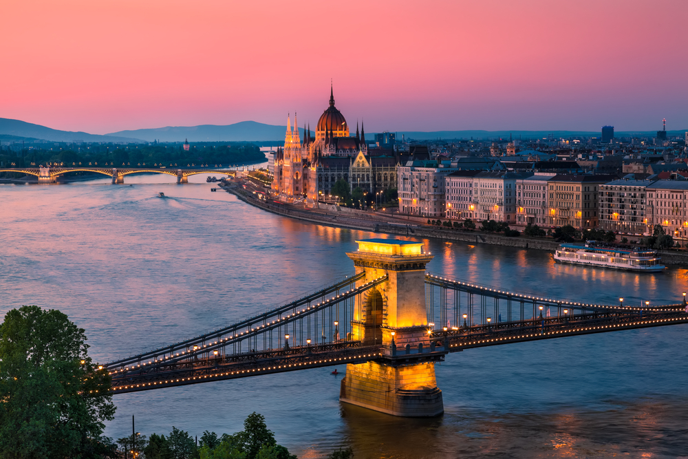 aerial photo of a lit bridge in the foreground and an arched bridge in the background, city along the river, one of the best places to visit in europe in march 