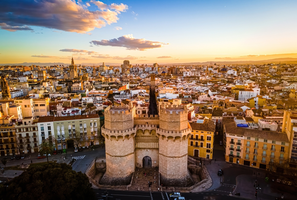 photo of a city from above, building tops are visible along with a flag flying atop a tower