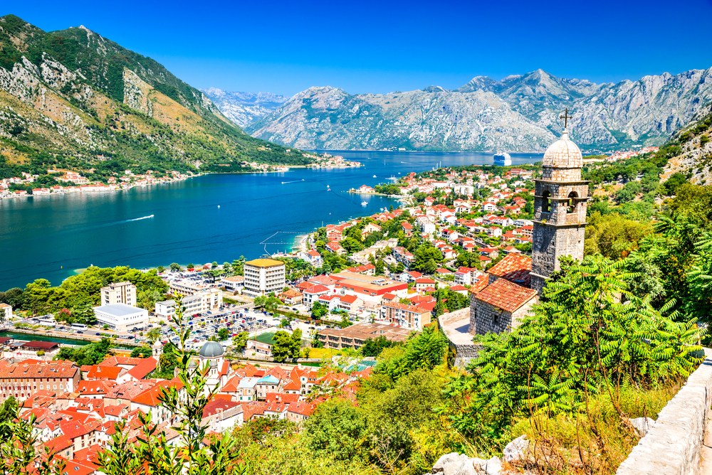 a photo of the bay of Motor. with mountains in the back round and an old church over looking to the pretty town.  